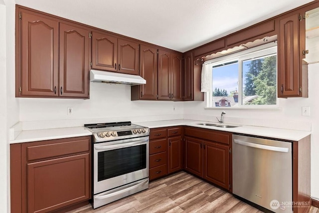 6114 47th Street Ct W, University Place, WA 98466 - kitchen featuring appliances with stainless steel finishes, under cabinet range hood, light countertops, and light wood-type flooring