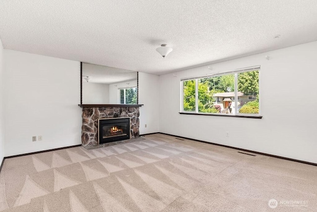 6114 47th Street Ct W, University Place, WA 98466 - unfurnished living room with a textured ceiling, a stone fireplace, and carpet
