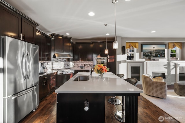 6511 108th Ave NE Unit 3, Kirkland, WA 98033 - kitchen with appliances with stainless steel finishes, light countertops, a tiled fireplace, recessed lighting, and dark wood finished floors