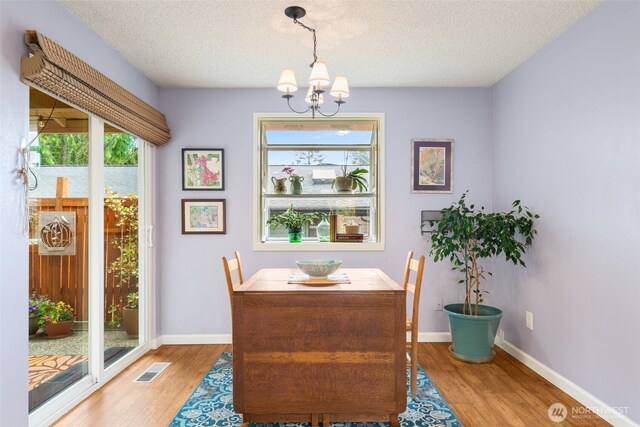 24812 12th Ave S, Des Moines, WA 98198 - dining area with a chandelier, wood finished floors, and a textured ceiling