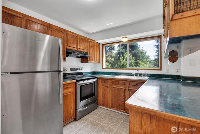 34716 4th Pl S, Federal Way, WA 98003 - kitchen with appliances with stainless steel finishes, under cabinet range hood, brown cabinets, and dark countertops