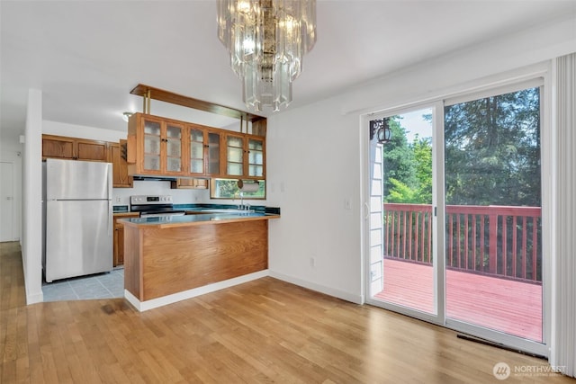 34716 4th Pl S, Federal Way, WA 98003 - kitchen with appliances with stainless steel finishes, brown cabinets, a chandelier, a peninsula, and light wood-style flooring
