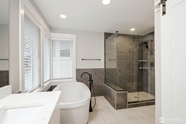7560 S 130th Pl, Seattle, WA 98178 - bathroom featuring a shower stall, a freestanding tub, vanity, recessed lighting, and marble look tile flooring