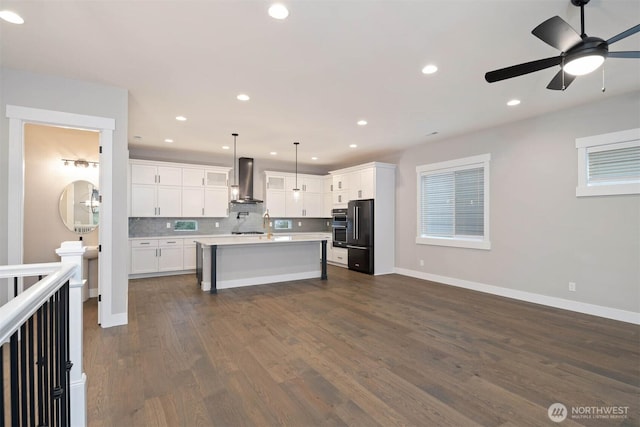 7560 S 130th Pl, Seattle, WA 98178 - kitchen featuring wall chimney exhaust hood, light countertops, dark wood-style floors, decorative backsplash, and freestanding refrigerator