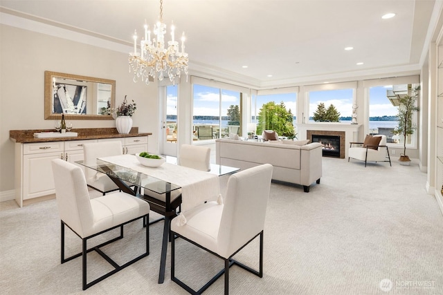 6424 Lake Washington Blvd NE Unit 34, Kirkland, WA 98033 - dining room featuring light carpet, a water view, crown molding, a glass covered fireplace, and a chandelier