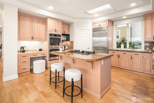6424 Lake Washington Blvd NE Unit 34, Kirkland, WA 98033 - kitchen featuring appliances with stainless steel finishes, a center island, a kitchen bar, light brown cabinetry, and ornamental molding