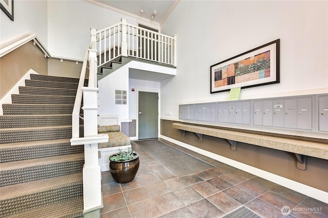 8021 234th St SW Unit 211, Edmonds, WA 98026 - stairs with mail area, a towering ceiling, and ornamental molding
