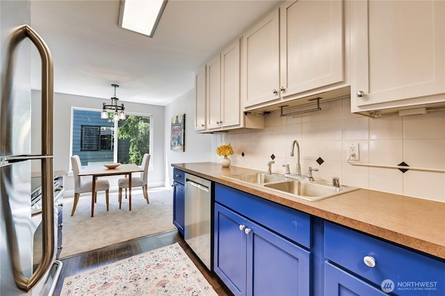 8021 234th St SW Unit 211, Edmonds, WA 98026 - kitchen with stainless steel appliances, blue cabinetry, backsplash, dark wood-style floors, and a chandelier