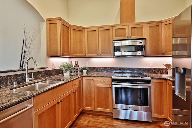 4880 Harbor Hills Dr, Freeland, WA 98249 - kitchen with appliances with stainless steel finishes, dark wood-type flooring, dark stone countertops, and brown cabinets