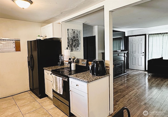 616 S Ironwood, Moses Lake, WA 98837 - kitchen with stainless steel electric range oven, white cabinets, dark stone countertops, light wood-style flooring, and black refrigerator with ice dispenser