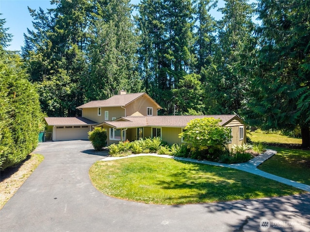 6426 Zangle Rd NE, Olympia, WA 98506 - traditional-style house featuring asphalt driveway, a garage, a front lawn, and a chimney