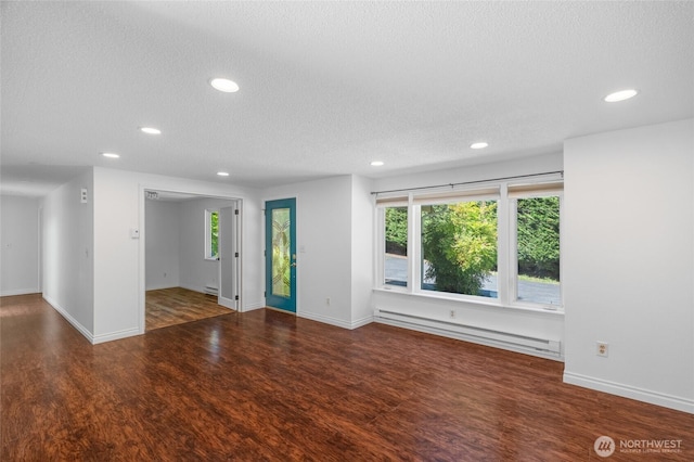 6426 Zangle Rd NE, Olympia, WA 98506 - unfurnished living room with a baseboard radiator, a textured ceiling, recessed lighting, wood finished floors, and plenty of natural light