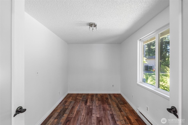 6426 Zangle Rd NE, Olympia, WA 98506 - unfurnished room featuring a baseboard radiator, dark wood finished floors, and a textured ceiling