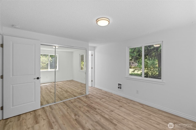 6426 Zangle Rd NE, Olympia, WA 98506 - unfurnished bedroom with wood finished floors, a textured ceiling, and a closet