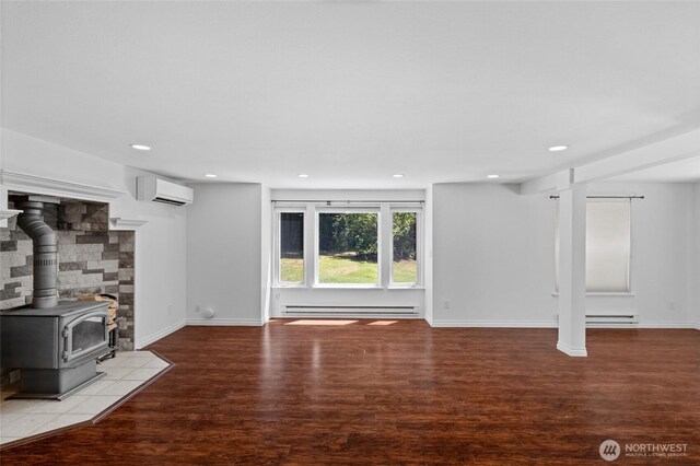 6426 Zangle Rd NE, Olympia, WA 98506 - unfurnished living room with a wall mounted AC, wood finished floors, recessed lighting, a baseboard radiator, and a wood stove