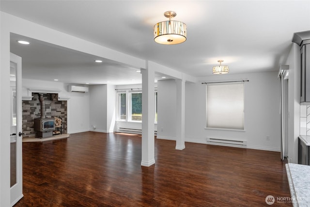 6426 Zangle Rd NE, Olympia, WA 98506 - unfurnished living room with a wall mounted air conditioner, baseboard heating, a wood stove, wood finished floors, and recessed lighting