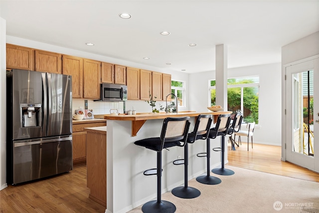 18353 160th Pl SE, Renton, WA 98058 - kitchen with stainless steel appliances, light countertops, a kitchen breakfast bar, recessed lighting, and light wood finished floors