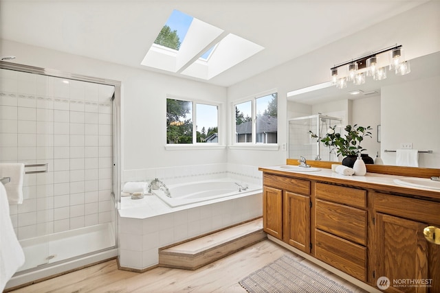 18353 160th Pl SE, Renton, WA 98058 - full bath featuring a skylight, a stall shower, a garden tub, double vanity, and wood finished floors