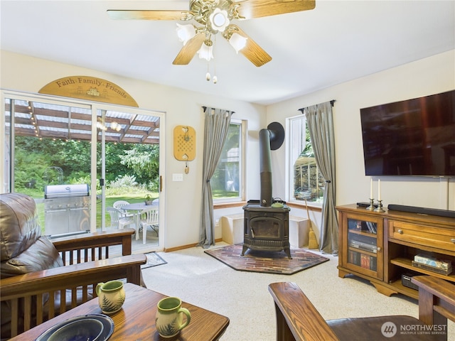 27014 80th St E, Buckley, WA 98321 - living area featuring ceiling fan, a wood stove, plenty of natural light, and carpet flooring