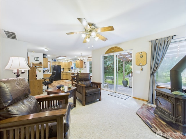 27014 80th St E, Buckley, WA 98321 - living area with a wood stove, a ceiling fan, and light carpet