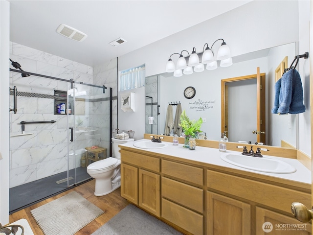 27014 80th St E, Buckley, WA 98321 - bathroom featuring a marble finish shower, double vanity, and wood finished floors