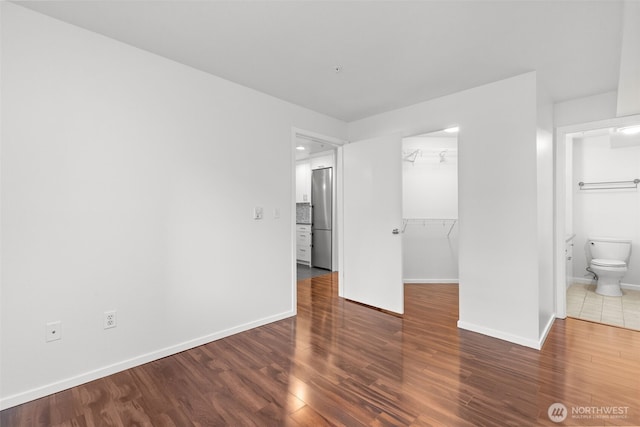 232 Belmont Ave E # 201, Seattle, WA 98102 - unfurnished bedroom with freestanding refrigerator, a spacious closet, wood finished floors, and connected bathroom
