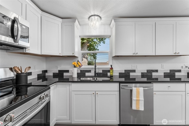 2112 S Crestmont Dr, Moses Lake, WA 98837 - kitchen featuring appliances with stainless steel finishes, white cabinets, a chandelier, and a textured ceiling
