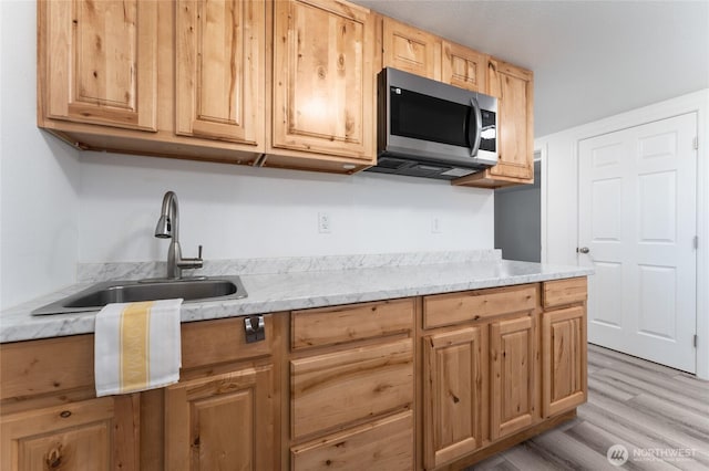 2112 S Crestmont Dr, Moses Lake, WA 98837 - kitchen featuring stainless steel microwave, light wood finished floors, light brown cabinets, and light stone countertops