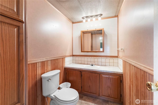 7138 Englewood Dr SE Unit 32, Olympia, WA 98513 - half bath featuring a wainscoted wall, vanity, a textured ceiling, ornamental molding, and wooden walls