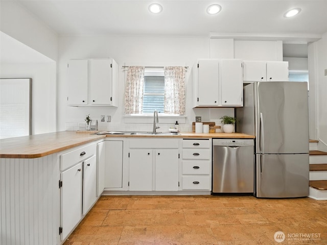 2555 Queen Anne Ave N, Seattle, WA 98109 - kitchen with appliances with stainless steel finishes, a peninsula, white cabinets, light countertops, and recessed lighting