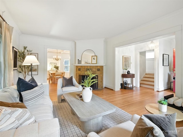 2555 Queen Anne Ave N, Seattle, WA 98109 - living area featuring a chandelier, light wood-style flooring, crown molding, stairs, and a brick fireplace