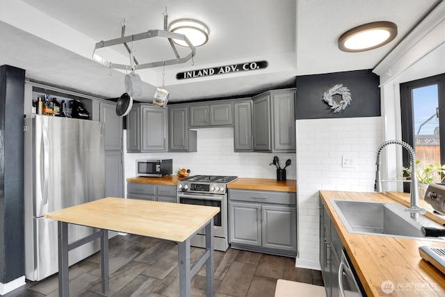 2819 W Olympic Ave, Spokane, WA 99205 - kitchen with wood counters, appliances with stainless steel finishes, gray cabinets, and decorative backsplash