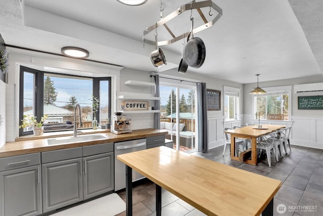 2819 W Olympic Ave, Spokane, WA 99205 - kitchen featuring wood counters, dishwasher, gray cabinets, healthy amount of natural light, and a wainscoted wall