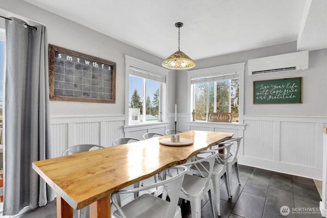 2819 W Olympic Ave, Spokane, WA 99205 - dining area with a wall mounted air conditioner, wainscoting, a decorative wall, and dark tile patterned floors