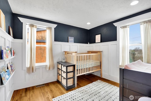 2819 W Olympic Ave, Spokane, WA 99205 - bedroom with a decorative wall, wood finished floors, a wainscoted wall, and recessed lighting
