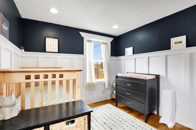 2819 W Olympic Ave, Spokane, WA 99205 - bedroom with a decorative wall, wainscoting, wood finished floors, and recessed lighting