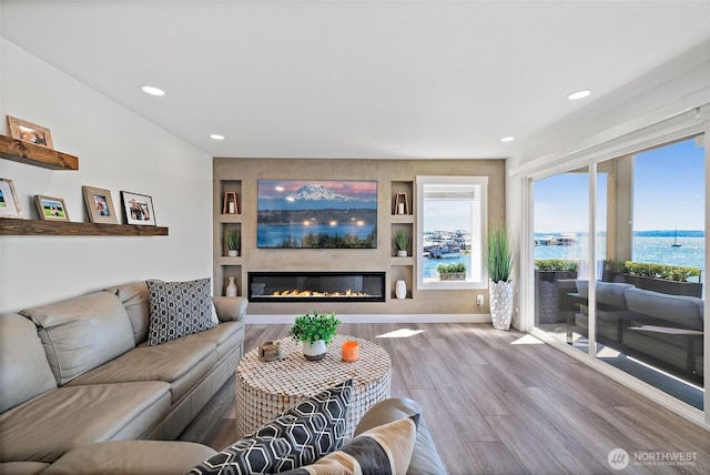 65 Kirkland Ave Unit 108, Kirkland, WA 98033 - living room featuring wood finished floors, a glass covered fireplace, recessed lighting, and built in shelves