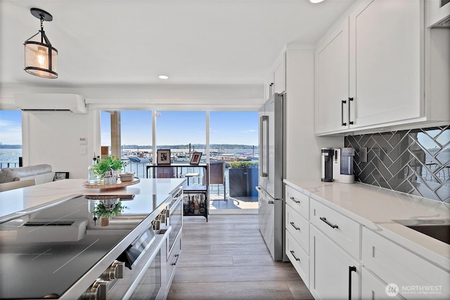 65 Kirkland Ave Unit 108, Kirkland, WA 98033 - kitchen featuring a wall unit AC, recessed lighting, high end refrigerator, white cabinetry, and light wood finished floors
