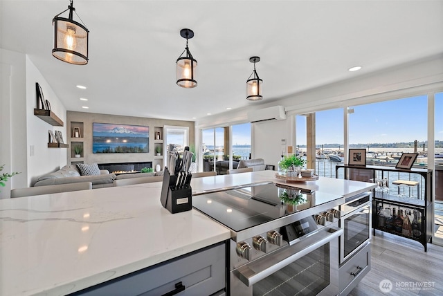 65 Kirkland Ave Unit 108, Kirkland, WA 98033 - kitchen with a wall mounted air conditioner, stainless steel range with electric cooktop, gray cabinets, open floor plan, and recessed lighting