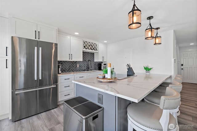 65 Kirkland Ave Unit 108, Kirkland, WA 98033 - kitchen featuring freestanding refrigerator, light wood finished floors, backsplash, a kitchen breakfast bar, and recessed lighting