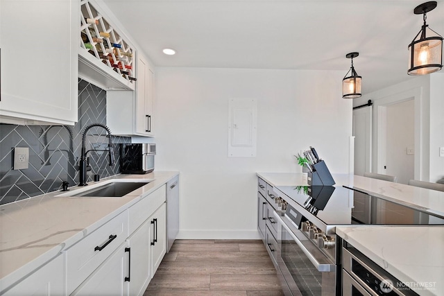 65 Kirkland Ave Unit 108, Kirkland, WA 98033 - kitchen with stainless steel appliances, wood finished floors, tasteful backsplash, hanging light fixtures, and white cabinets