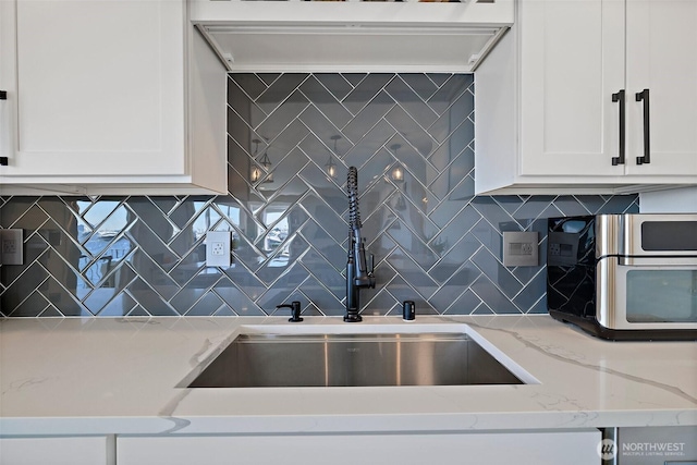 65 Kirkland Ave Unit 108, Kirkland, WA 98033 - kitchen featuring ventilation hood, white cabinetry, decorative backsplash, and light stone counters