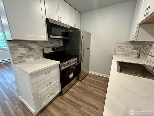 9623 S 248th St Unit D4, Kent, WA 98030 - kitchen with stainless steel appliances, light stone counters, wood finished floors, and tasteful backsplash