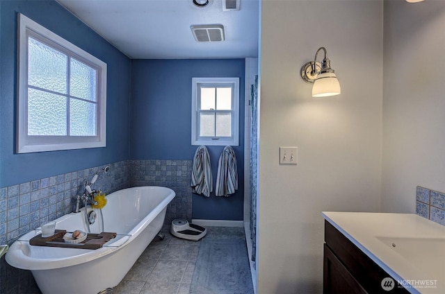 1609 Russell St, Wenatchee, WA 98801 - full bath featuring vanity, a freestanding tub, tile patterned flooring, tile walls, and a wainscoted wall