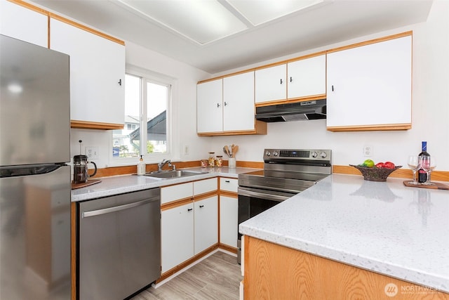 8823 Holly Dr Unit H206, Everett, WA 98208 - kitchen with stainless steel appliances, under cabinet range hood, white cabinets, light wood-style floors, and light stone countertops
