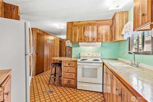 2400 Donovan Unit 67, Bellingham, WA 98225 - kitchen featuring white appliances, under cabinet range hood, light countertops, and brown cabinets