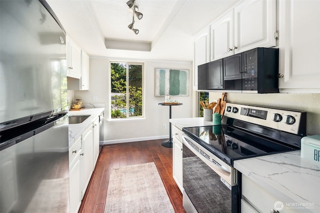 4635 W Lake Sammamish Pkwy SE Unit G206, Issaquah, WA 98027 - kitchen featuring stainless steel appliances, dark wood finished floors, a tray ceiling, light stone counters, and white cabinetry