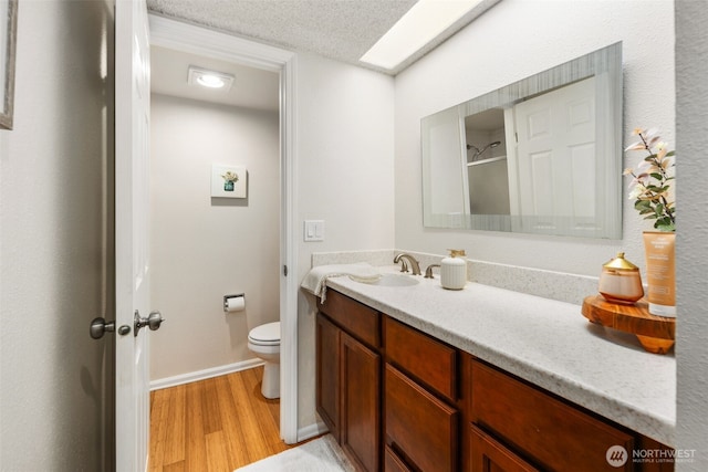 4635 W Lake Sammamish Pkwy SE Unit G206, Issaquah, WA 98027 - bathroom featuring wood finished floors, vanity, and a textured ceiling