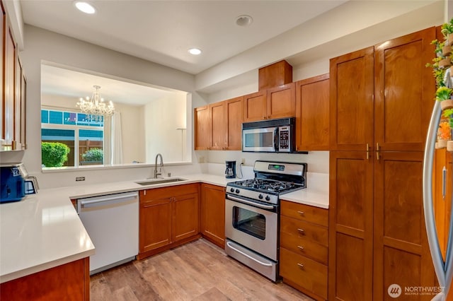 18526 36th Ave W Unit C, Lynnwood, WA 98037 - kitchen featuring appliances with stainless steel finishes, brown cabinets, a chandelier, light wood-type flooring, and recessed lighting