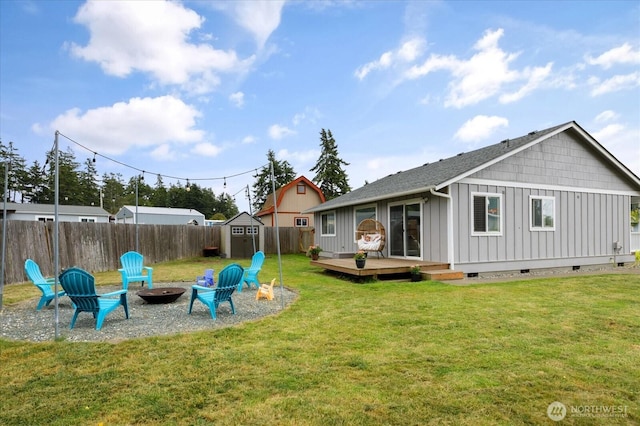 1664 Allyson St, Oak Harbor, WA 98277 - rear view of property featuring board and batten siding, a fire pit, a deck, a storage unit, and a fenced backyard